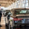 Professional black car service with uniformed chauffeur standing beside luxury sedan at Chicago O'Hare airport